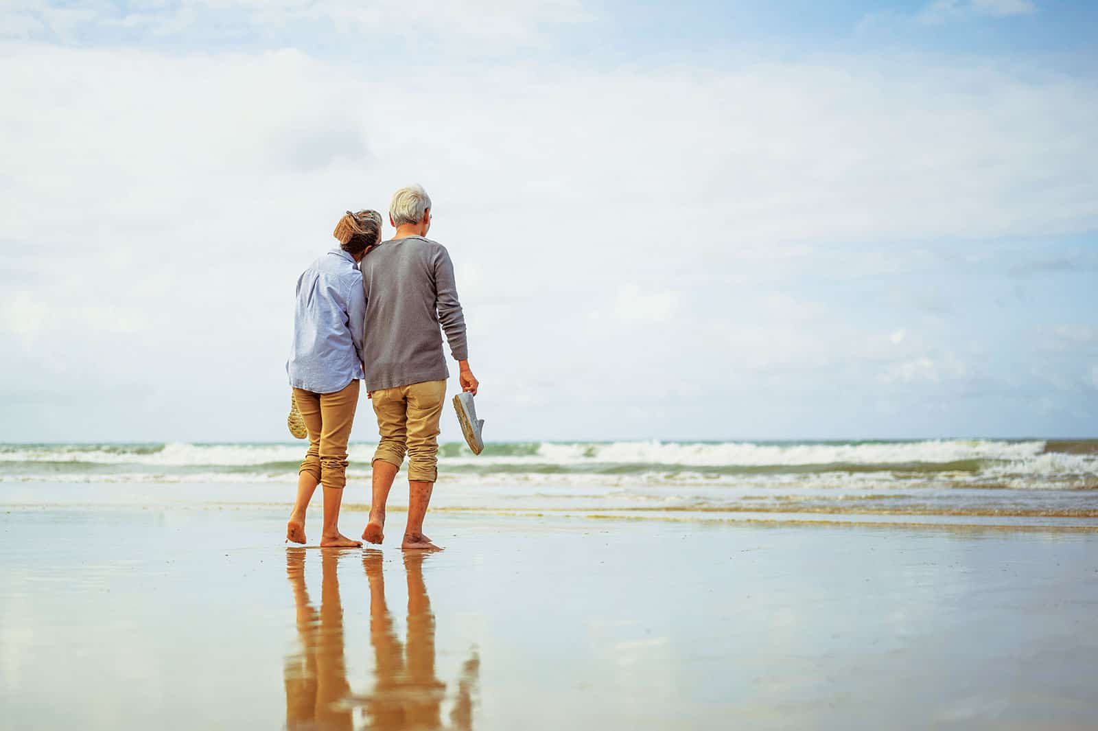 Seniors Walking On Beach